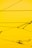 Cables crisscrossing against a bright yellow background with a few mechanical components attached.