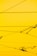 Cables crisscrossing against a bright yellow background with a few mechanical components attached.