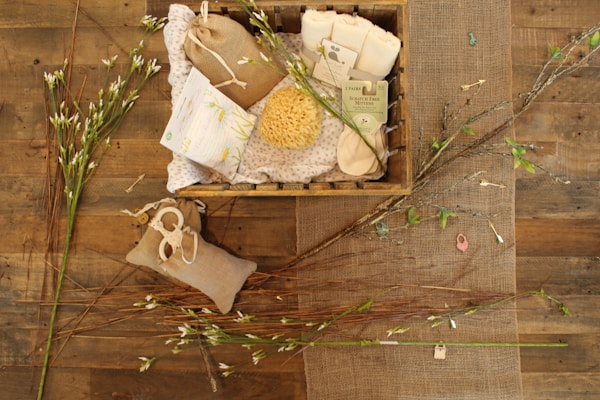 A cozy flat lay of natural bath salts, a wooden spoon, and a soft towel on a rustic wooden surface.