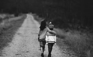 grayscale photography of kids walking on road