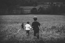 three boys running on field