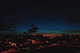 A cityscape at dusk with subtle red, white, and blue tones in the sky.