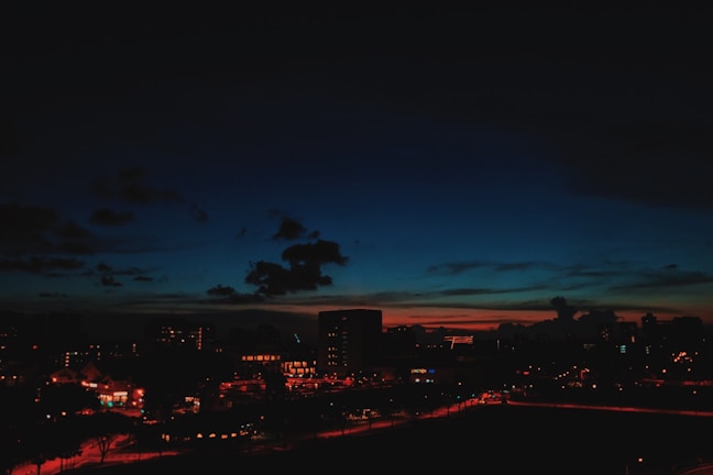 A cityscape at dusk with subtle red, white, and blue tones in the sky.