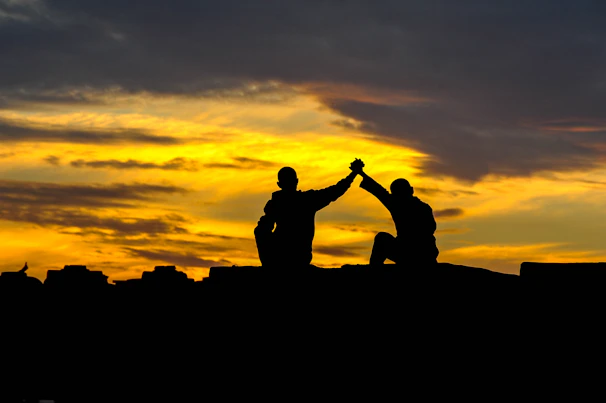 Friends cheering and high-fiving after a long rally, framed by bold black-and-white contrast.