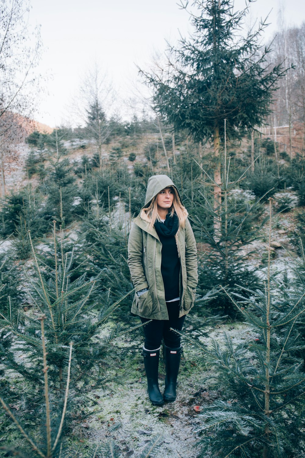 woman standing near pine trees