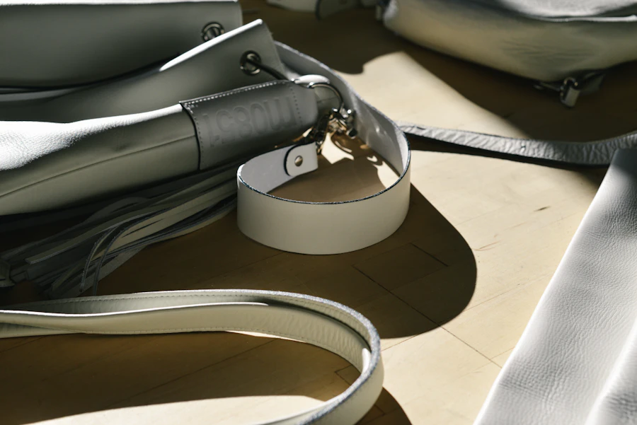 Un sac en cuir gris posé sur un fond clair, lumière douce et naturelle