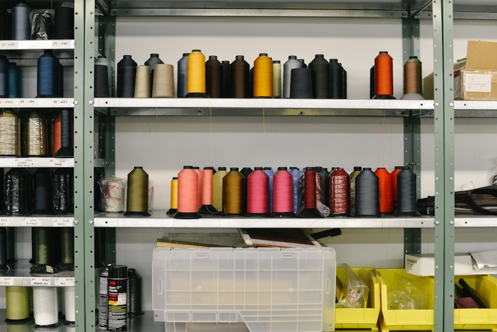 pile of assorted-color sewing threads on shelf