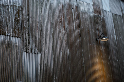 Finished custom metal sign with rustic industrial finish mounted on a textured wall.