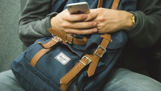 man holding his phone while sitting on chair