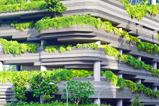 Grey concrete building partly screened by trees