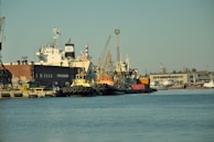 Wide shot of a bustling port area with various marine equipment undergoing safety checks.