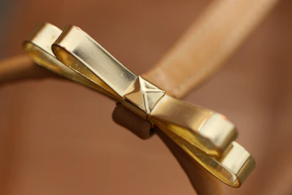 Close-up of a delicate handmade bow clip resting on soft fabric, highlighting its fine details and craftsmanship.