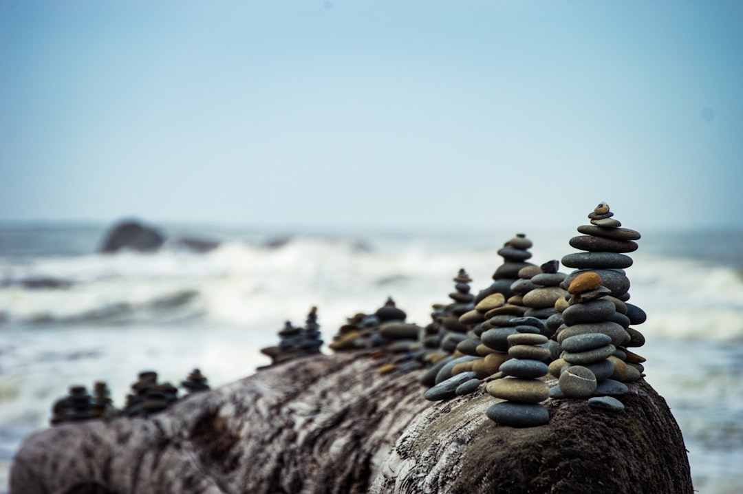 shallow focus photography of rock formation, Pebble piles on a big rock