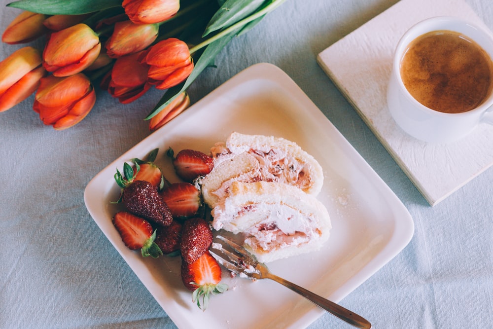 dessert with sliced strawberry fruits in bowl with gray stainless steel fork