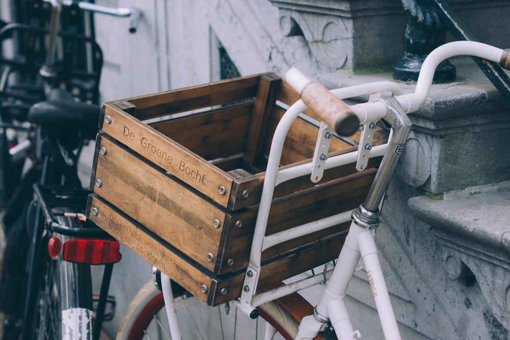 Caja de madera marrón en bicicleta blanca