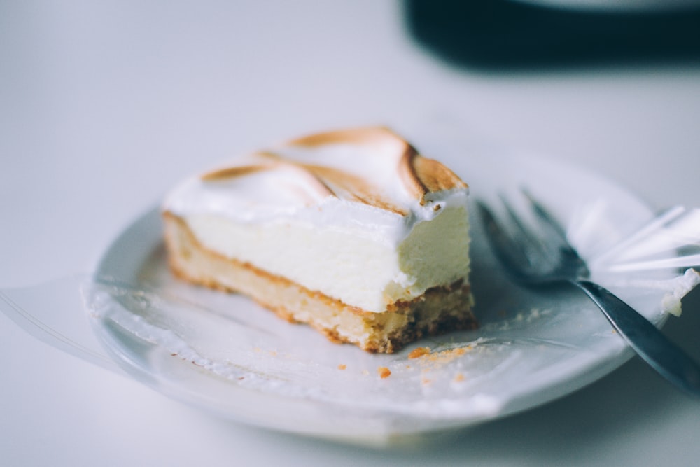 sliced of cake on round white plate with silver fork