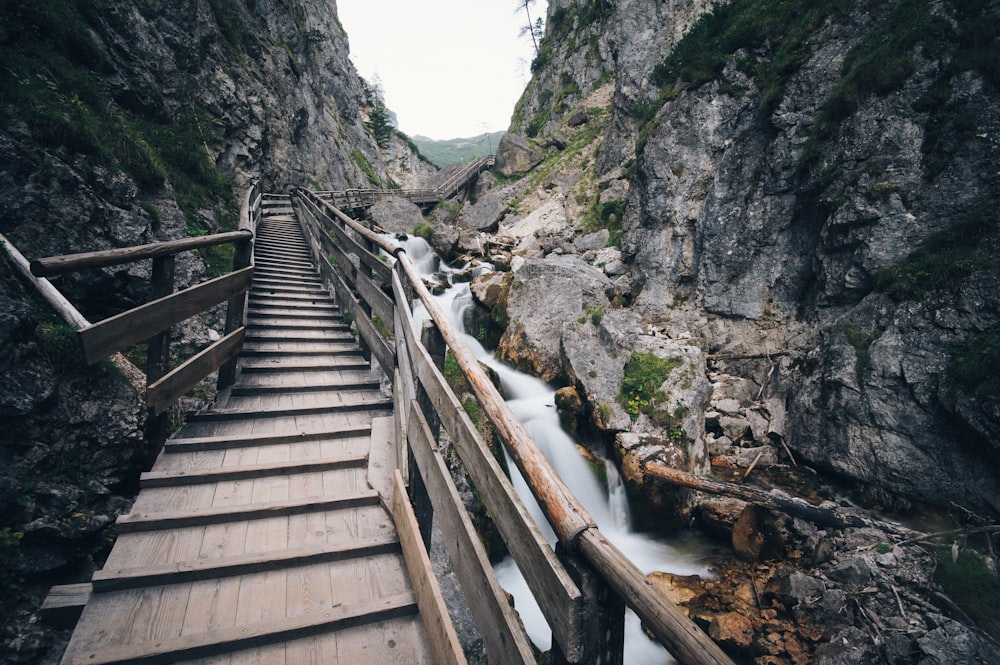 Pont en bois brun au milieu de deux montagnes