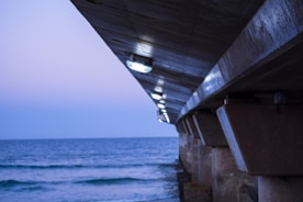 Waterfront pier supported by sturdy engineered pilings at sunset.