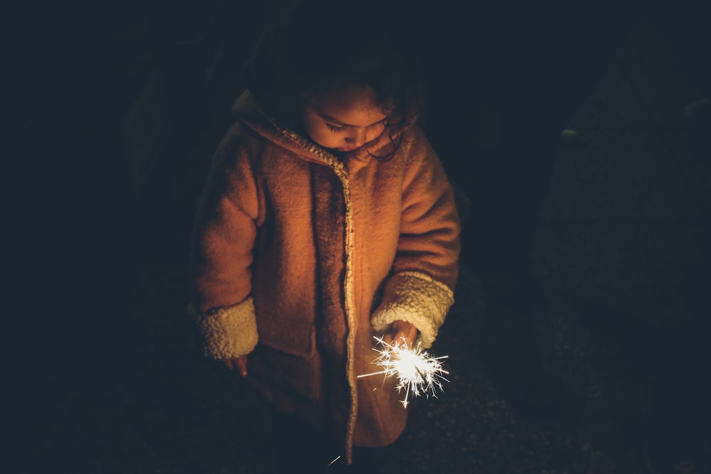 girl holding sparkler at nighttime