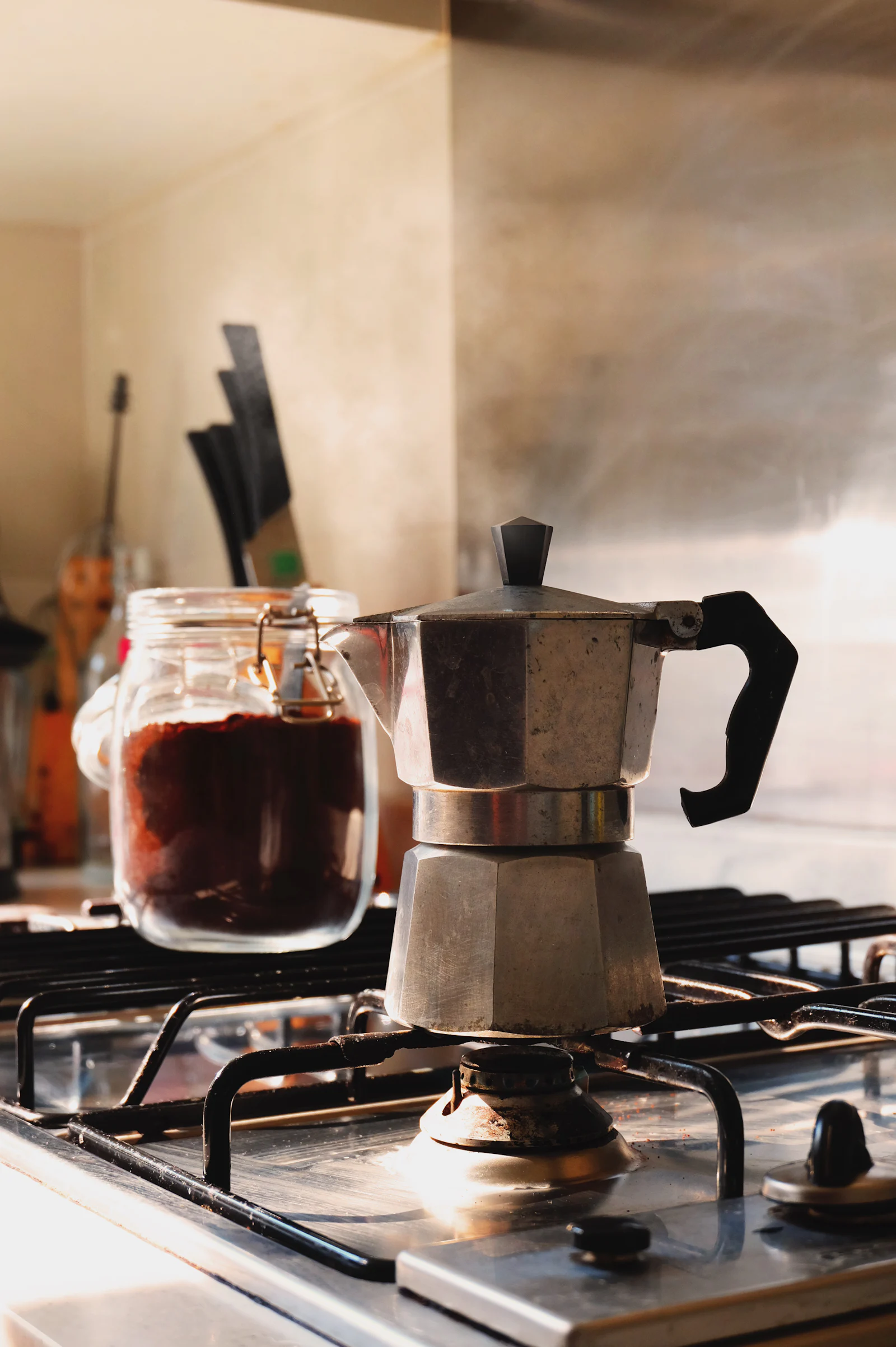 A moka pot heating on a gas ring.