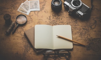 flat ray photography of book, pencil, camera, and with lens