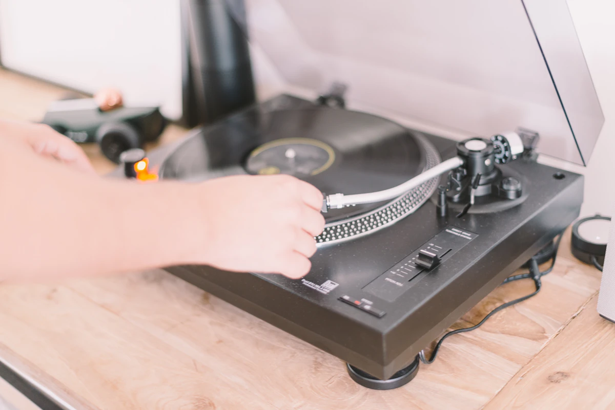 Hand cueing a record on a turntable; contemporary illustration