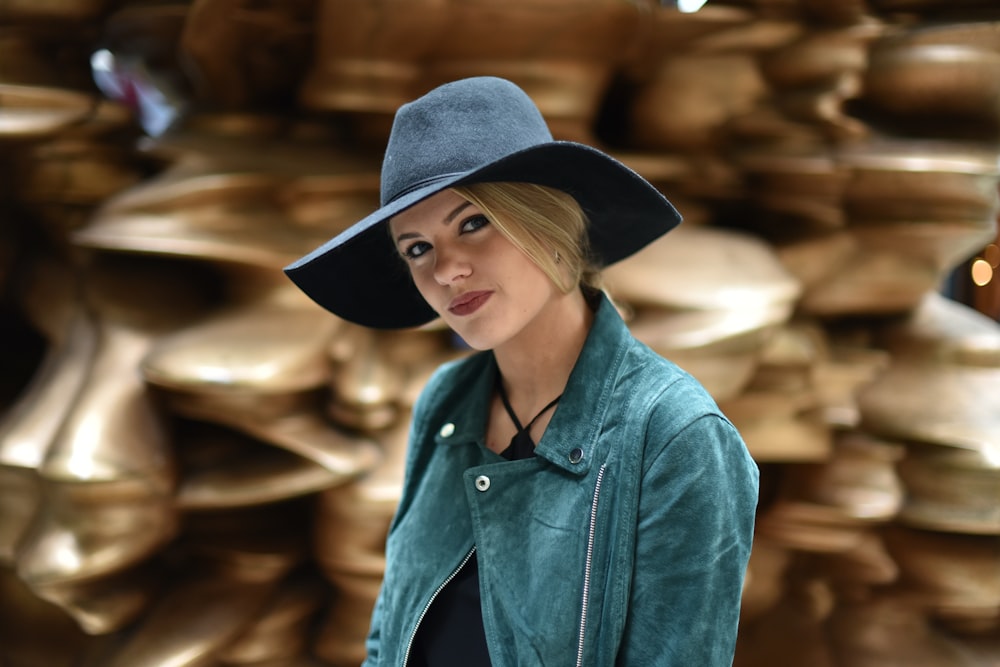 woman in green button-up jacket smiles with brown background