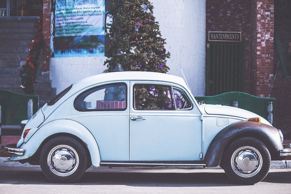 weißer Oldtimer in der Nähe des Weihnachtsbaums