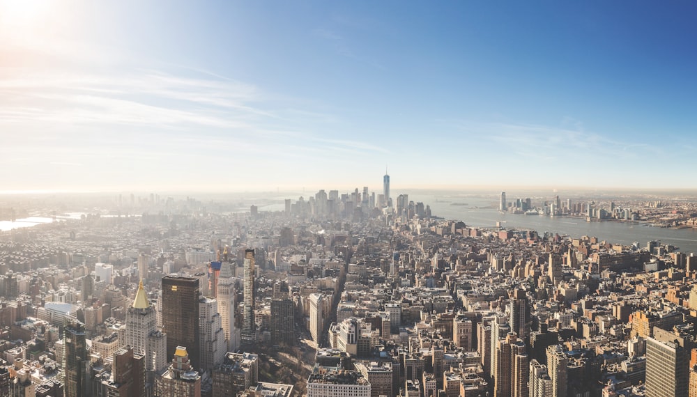 aerial photography of city high-rise buildings surrounded body of water during daytime