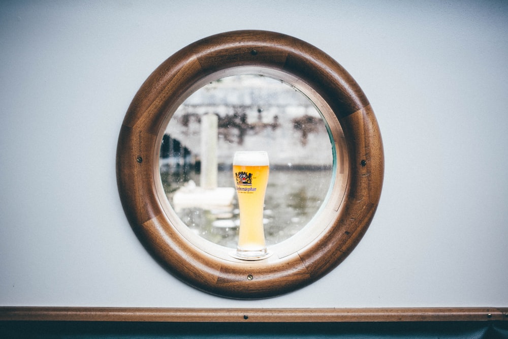 clear glass filled with yellow liquid on window