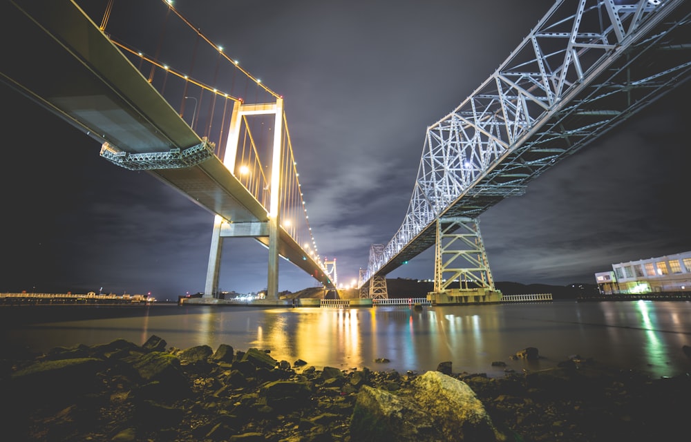 low angle photography of two metal bridges above body of water