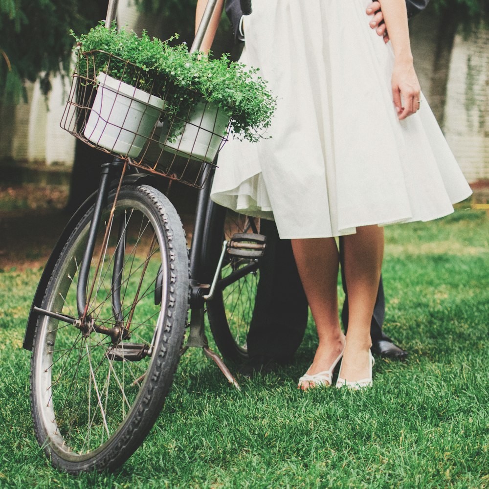 person standing besides black bicycle