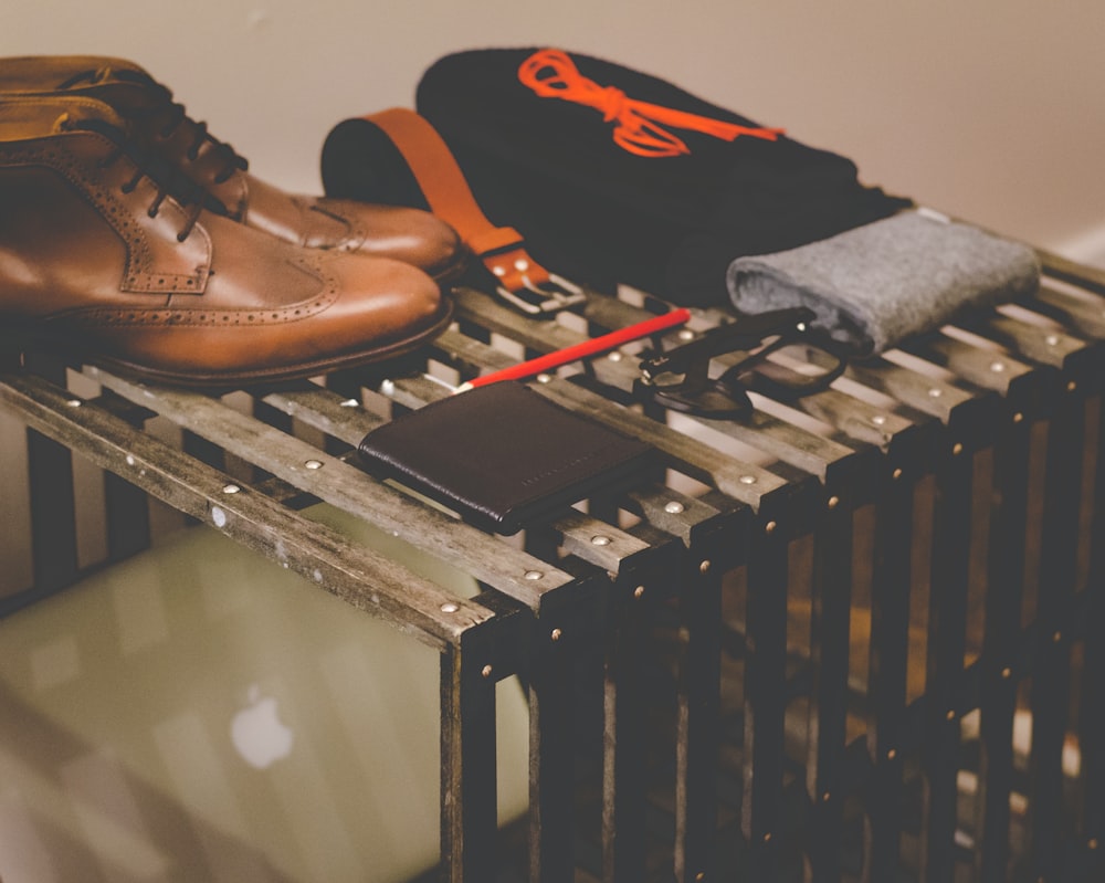 pair of brown leather dress shoes beside black leather wallet