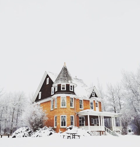 orange and gray concrete house surround by snow