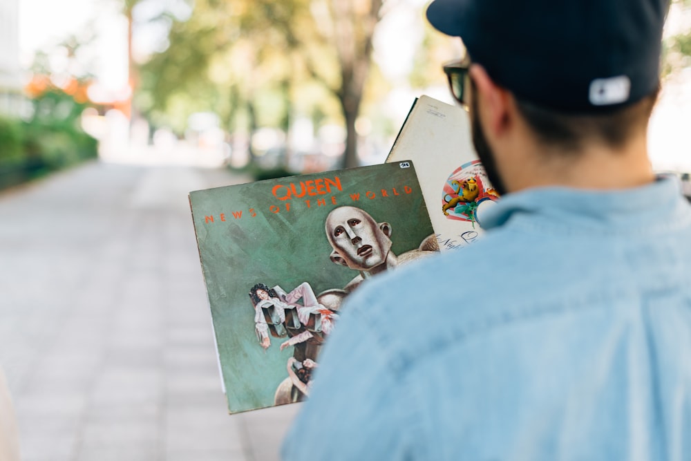 hombre sosteniendo un álbum de vinilo en fotografía de enfoque superficial