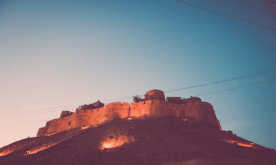 Sunset view over the medieval fort of Flaujac with the stone house warmly lit.