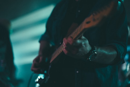 Close-up of a guitarist playing a blues solo in a dimly lit studio