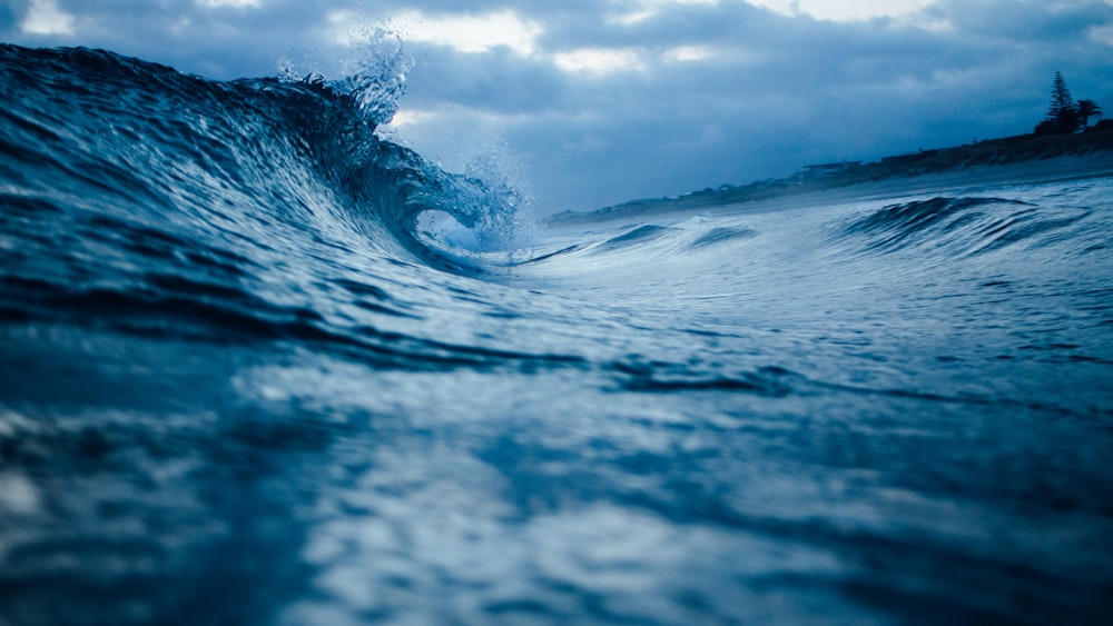 ocean wave under cloudy sky