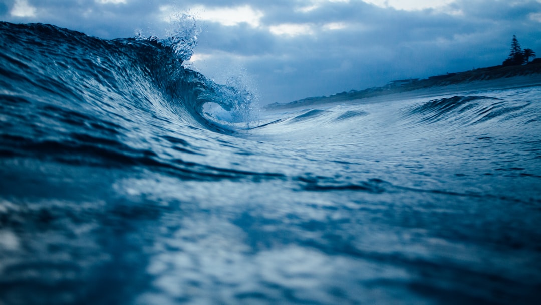 ocean wave under cloudy sky,