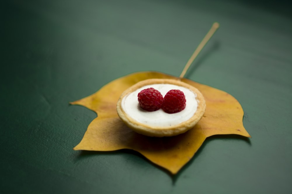 baga vermelha em cima de creme em fotografia de foco raso