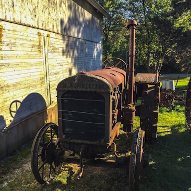 Farm equipment parked near a barn on a sunny day.