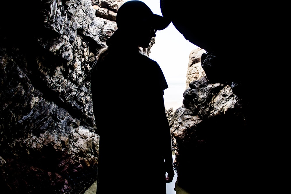 silhouette of woman standing inside cave