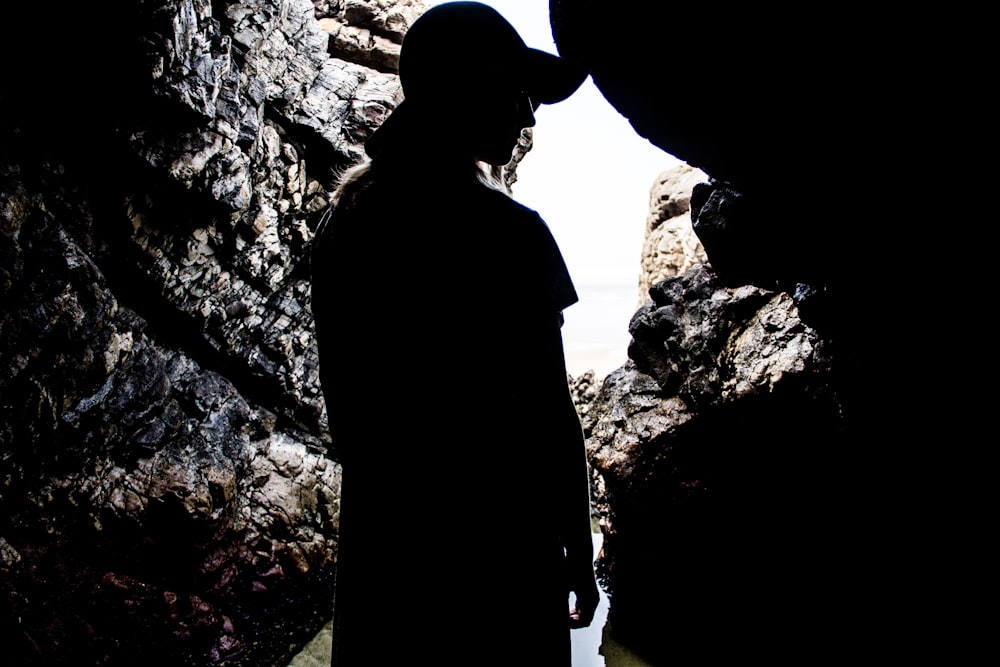 silhouette di donna in piedi all'interno della grotta