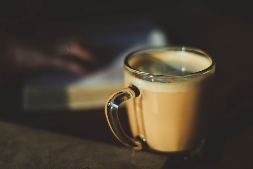 clear glass mug filled with brown liquid