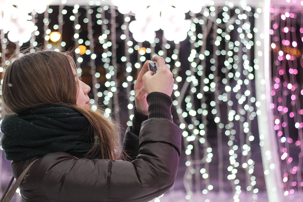 woman in black scarf using smartphone