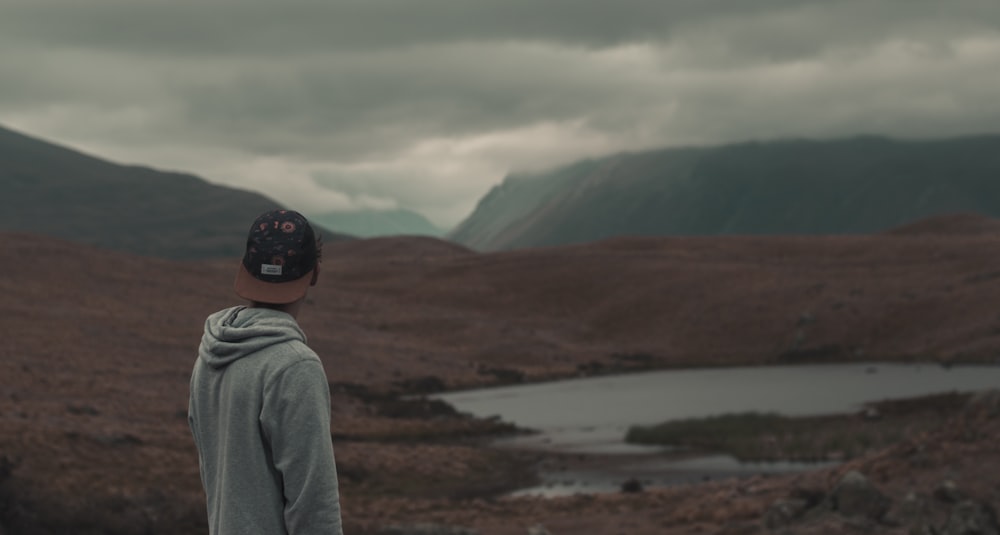 Foto de hombre con sudadera con capucha gris y gorra negra