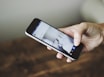 Hands holding a smartphone displaying social media icons