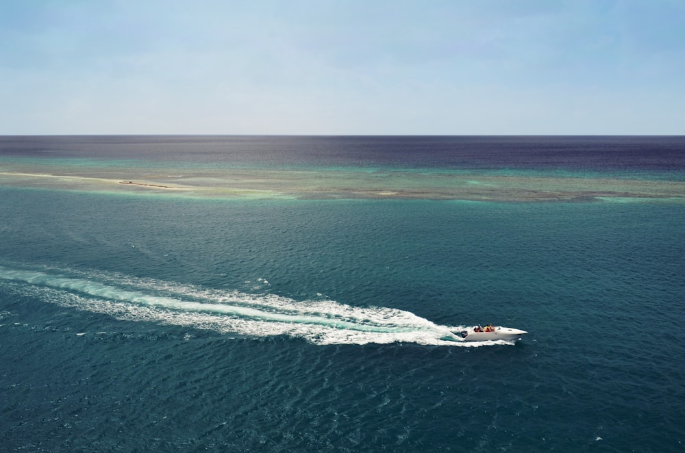 white speedboat running in middle of ocean during daytime