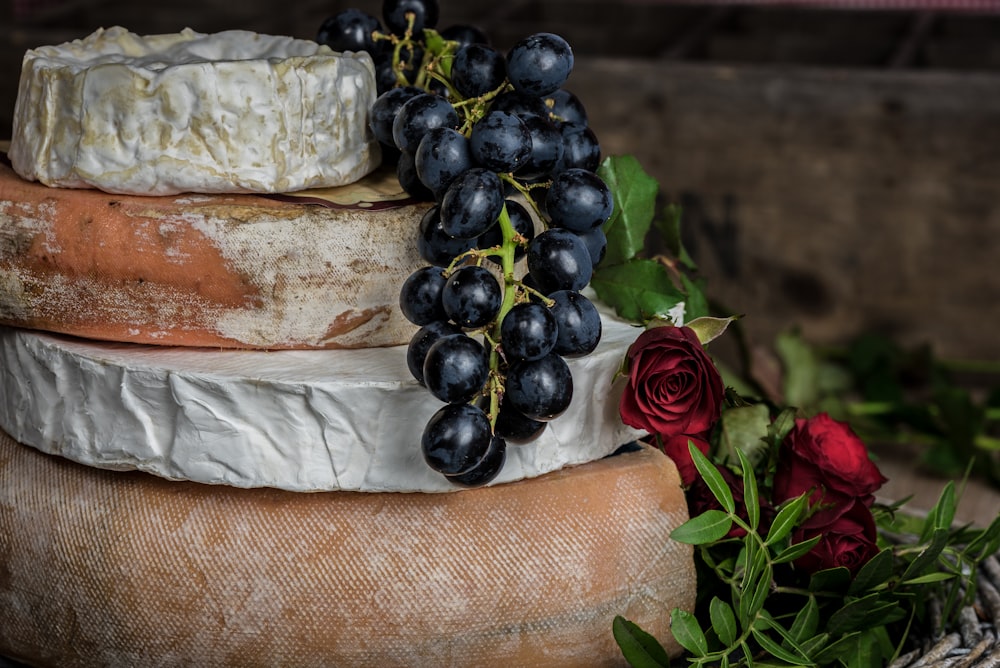 Frutto dell'uva appeso vicino alla rosa rossa