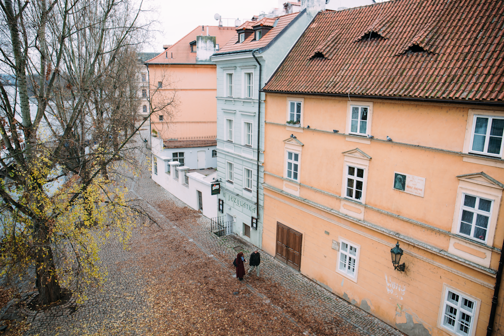 낮 동안 녹색 나무 사진 근처의 3 층 집 밖을 걷는 남자와 여자